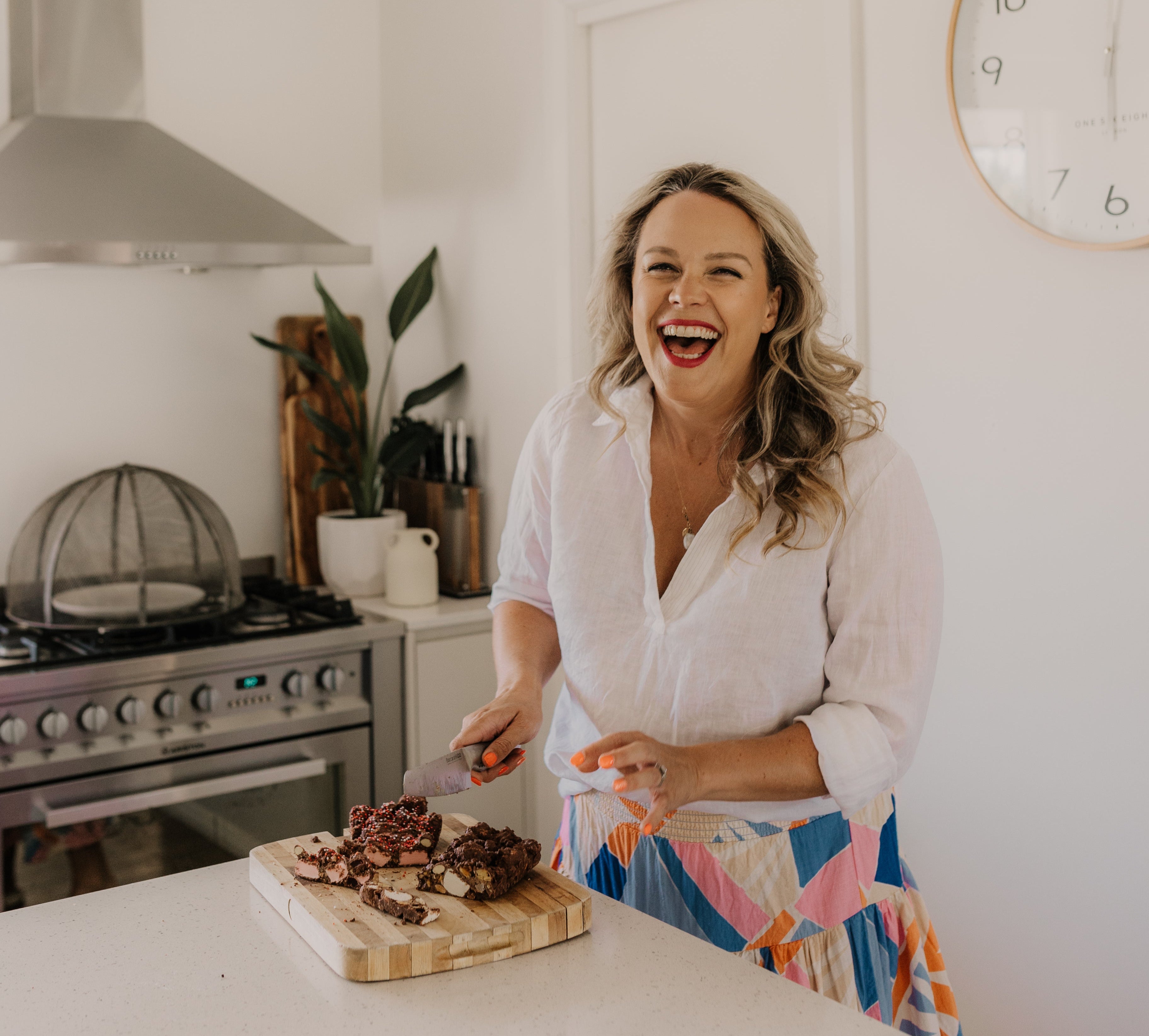 Woman in a kitchen preparing food, laughing