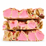 Raspberry Roundabout white chocolate rocky road stacked on a white background with pink marshmallows, raspberries and almonds.