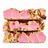 Raspberry Roundabout white chocolate rocky road stacked on a white background with pink marshmallows, raspberries and almonds.