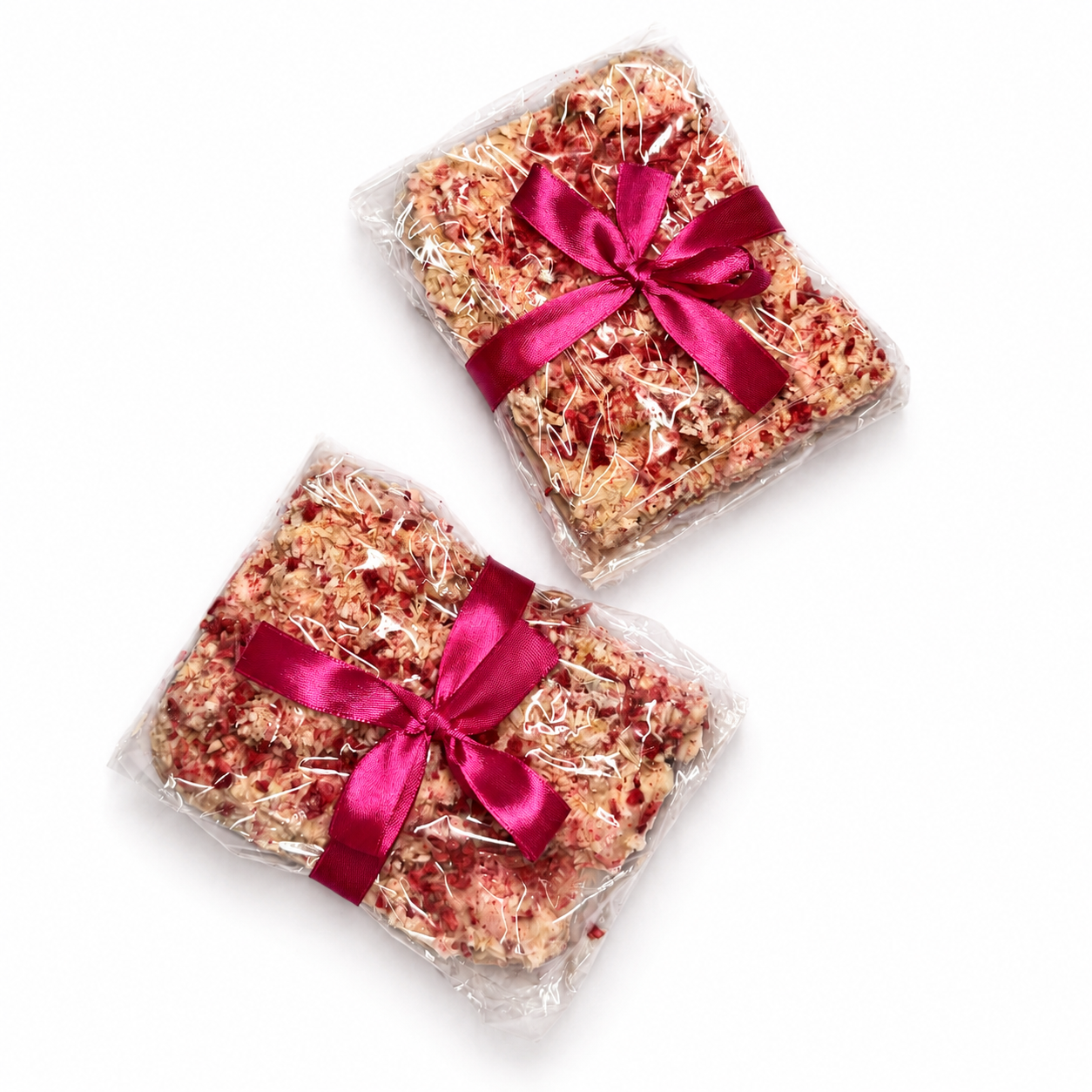 Two gift-wrapped Raspberry Roundabout rocky road blocks in clear wrap with pink ribbon on a white background.