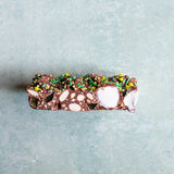 Chocolate bar with nuts and marshmallows and peppermint jellies on a light gray background