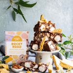 Pebbly Path Honeycomb Highway Rocky Road 200g box displayed with chunky rocky road pieces, honeycomb shards, marshmallows, roasted almonds, and native greenery on a styled dessert setting.