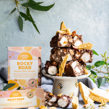 Pebbly Path Honeycomb Highway Rocky Road 200g and 100g boxes displayed with chunky rocky road pieces, honeycomb shards, marshmallows, almonds, and styled native greenery.