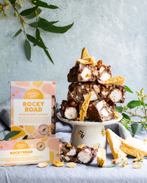Pebbly Path Honeycomb Highway Rocky Road 200g and 100g boxes displayed with chunky rocky road pieces, honeycomb shards, marshmallows, almonds, and styled native greenery.