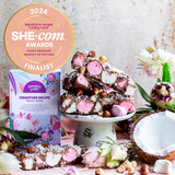Pebbly Path personalised box of custom rocky road displayed alongside stacked rocky road pieces, marshmallows, hazelnuts and coconut, featuring a 2024 SHE-com Awards finalist badge in a styled product scene.