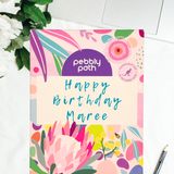 Pebbly Path personalised box of custom rocky road chocolate with handwritten birthday message on floral gift packaging, displayed on a desk beside a laptop and pen.