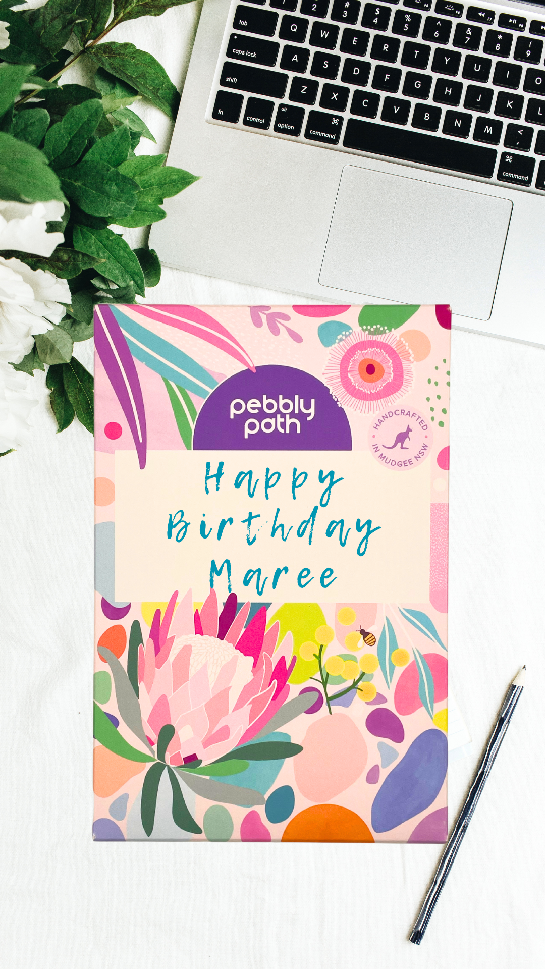 Pebbly Path personalised box of custom rocky road chocolate with handwritten birthday message on floral gift packaging, displayed on a desk beside a laptop and pen.