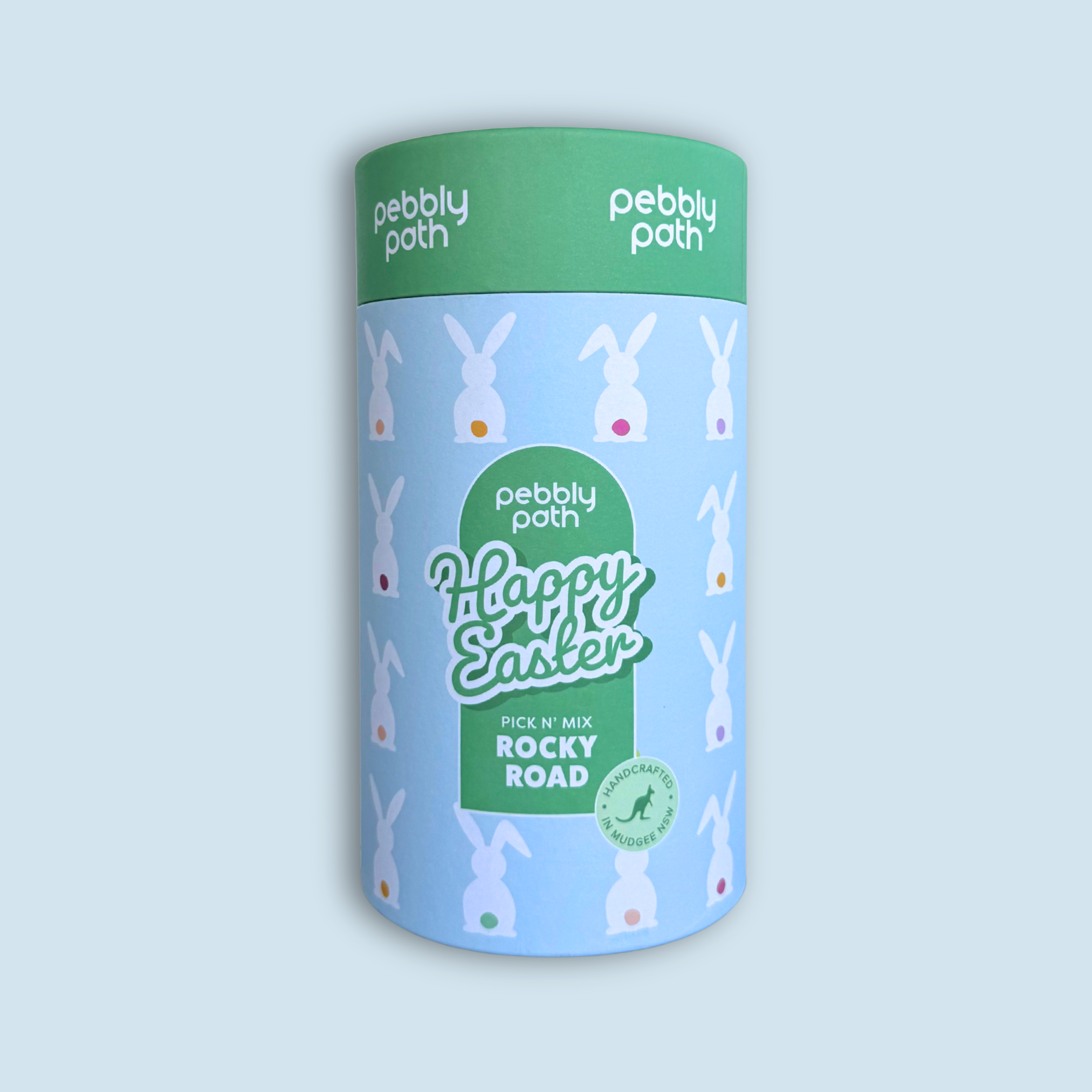 Light blue Pebbly Path Pick n Mix Rocky Road Easter cylinder with white bunny pattern, green lid and green label reading “Happy Easter”, handmade in Mudgee, NSW.
