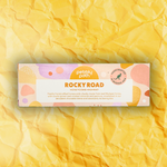 Pebbly Path Honeycomb Highway Rocky Road 100g box displayed on a textured yellow background with branded pastel packaging design.