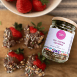 Pebbly Path ice-cream crumble jar beside fresh strawberries and chocolate treats, an Australian handmade chocolate topping for desserts.