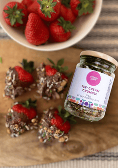 Pebbly Path ice-cream crumble jar beside fresh strawberries and chocolate treats, an Australian handmade chocolate topping for desserts.