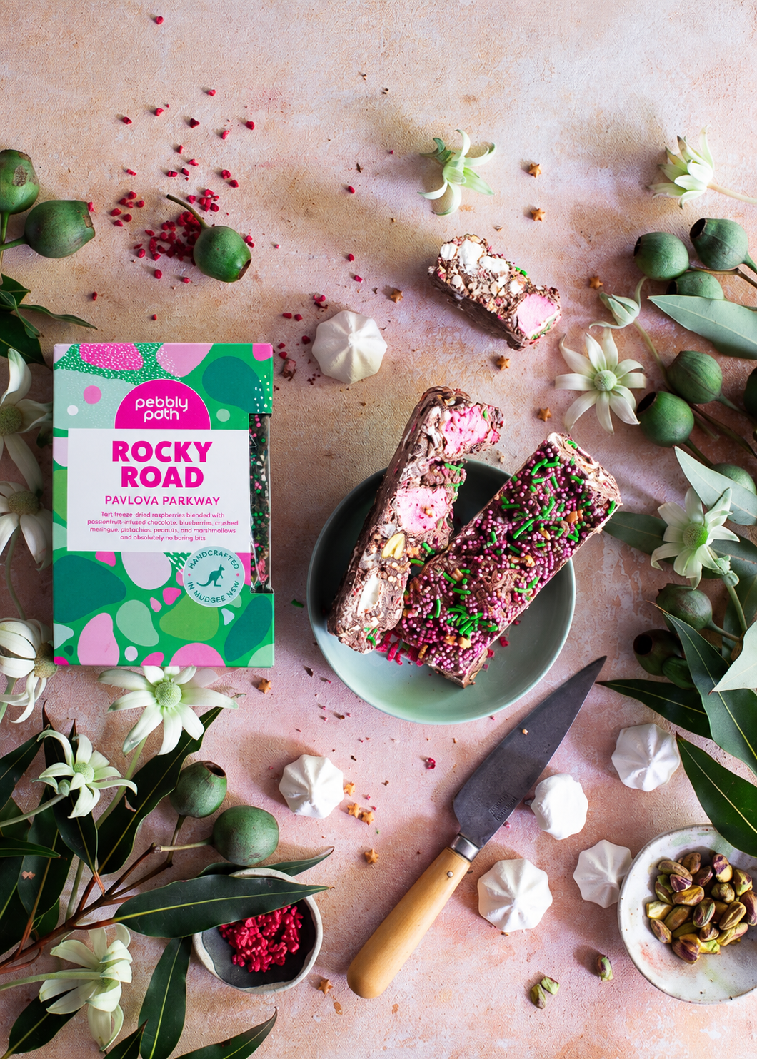 Pebbly Path Pavlova Parkway rocky road 200g box and rocky road pieces arranged with meringue, pistachios and raspberries.