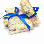 Pebbly Path White Chocolate Signature Recipe Rocky Road gift bundle featuring three individually wrapped packs tied with blue ribbons, displayed together on a white background with visible coconut flakes and white chocolate coating.