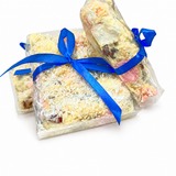 Pebbly Path White Chocolate Signature Recipe Rocky Road gift bundle featuring three individually wrapped packs tied with blue ribbons, displayed together on a white background with visible coconut flakes and white chocolate coating.
