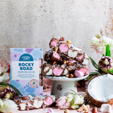 Pebbly Path Signature Recipe Rocky Road displayed with chunky marshmallows, roasted hazelnuts, coconut flakes, fresh flowers, and branded gift packaging on a styled dessert table.