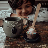 Pebbly Path Hot Chocolate Pop with marshmallow and colourful sprinkles beside a koala mug as a child enjoys a cosy hot chocolate moment at home